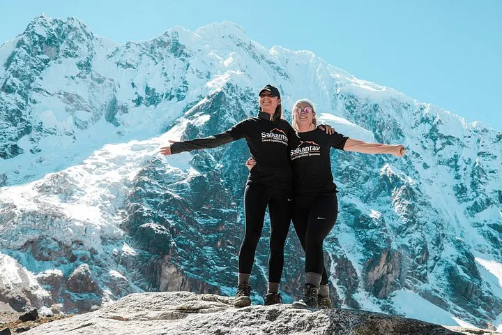 Hikers on a Salkantay trek tour below the snow peaks on a small group Salkantay trek tour from Cusco, Peru